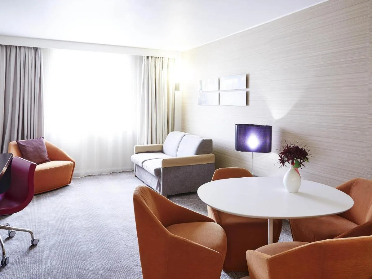 a living room with a couch and a table and chairs at Novotel Liverpool Centre in Liverpool