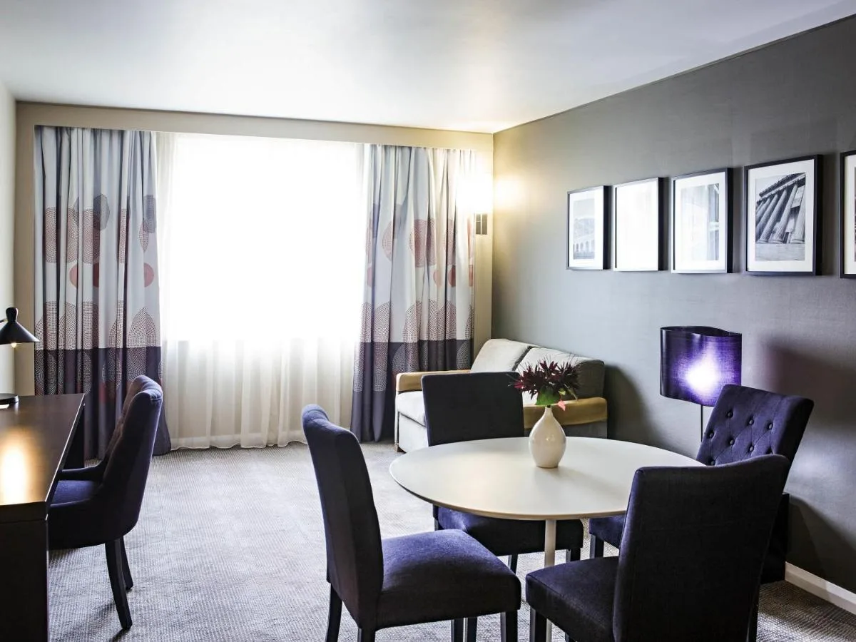a living room with a table and chairs and a couch at Novotel Liverpool Centre in Liverpool