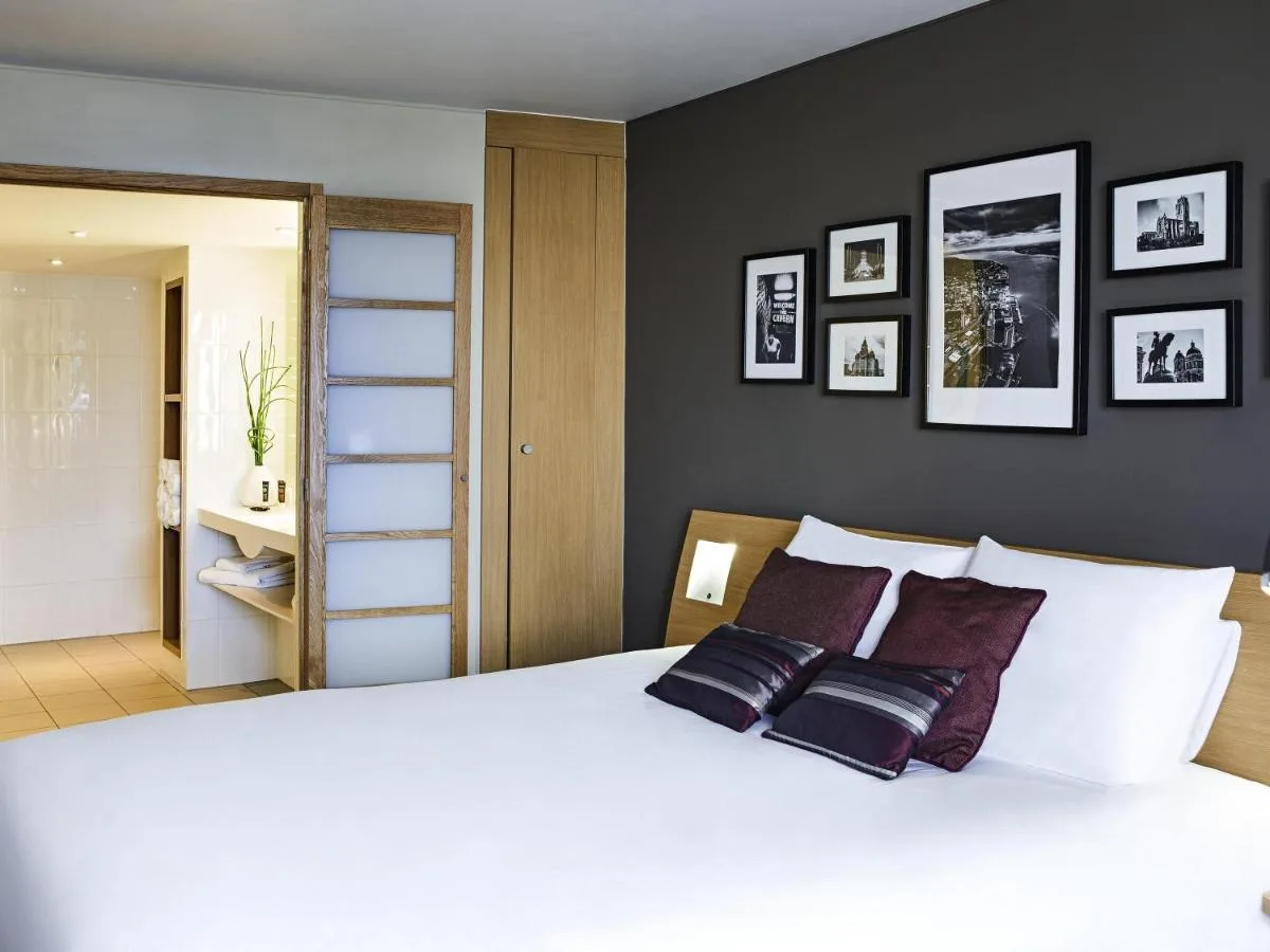 a bedroom with a large white bed with three pillows at Novotel Liverpool Centre in Liverpool