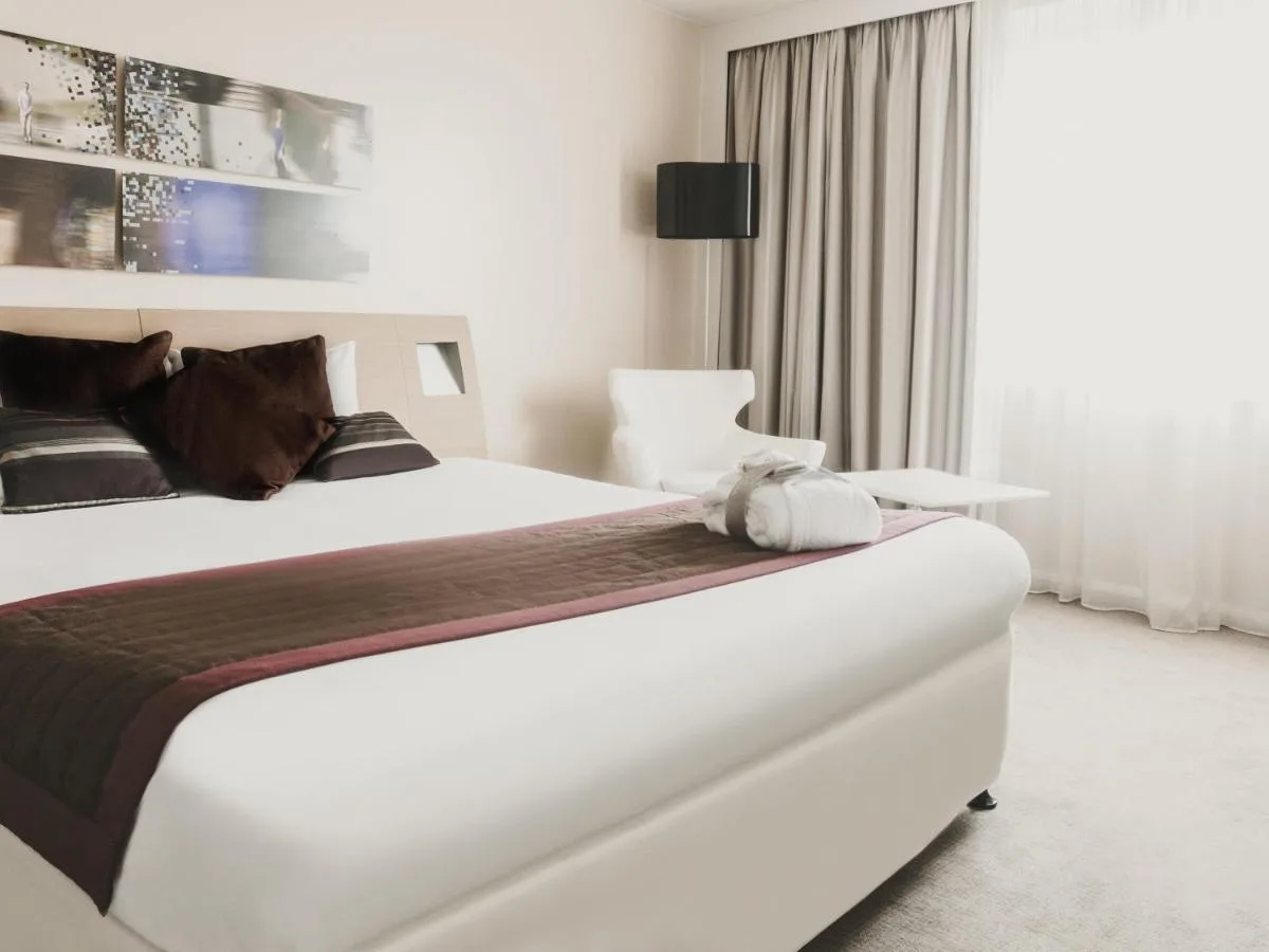 a bedroom with a large white bed and a window at Novotel Liverpool Centre in Liverpool